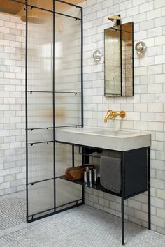 a white tiled bathroom with a sink and shower stall next to it's mirror