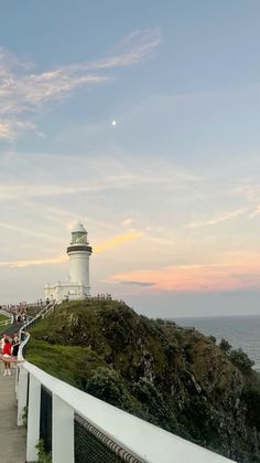 people are standing on the walkway near the lighthouse