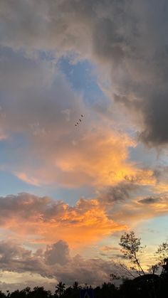 the sky is filled with clouds and birds flying in the distance at sunset or dawn