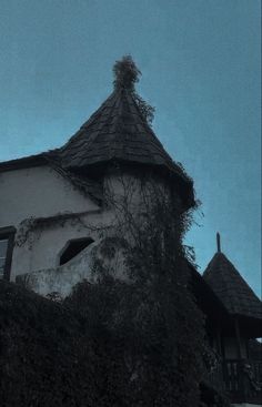 an old building with vines growing on it's side and a clock tower in the background