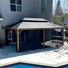 a pool with a gazebo next to a house