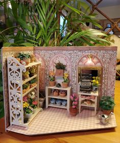 a doll house with potted plants and shelves