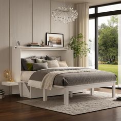 a white bed sitting next to a window in a room with wooden floors and walls