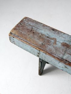 an old wooden bench sitting on top of a white floor