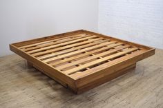 a wooden bed frame sitting on top of a hard wood floor