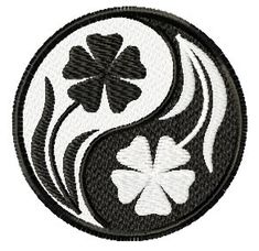 a yin yang symbol with four leaf clovers in the center on a black and white background