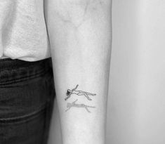 a black and white photo of a woman's arm with a tattoo on it