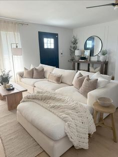 a large white couch sitting in a living room next to a window