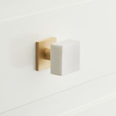 a white and gold door handle on a white wall