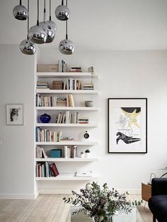 a living room filled with furniture and bookshelves next to a wall mounted book shelf