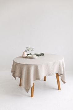 a table with a white cloth on it and two cups sitting on top of it