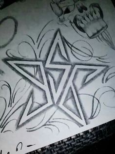 a drawing of a star on paper with some writing underneath it and an ink pen next to it