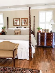 a large bed sitting in the middle of a bedroom on top of a hard wood floor