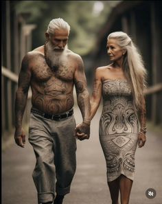 a man and woman walking down a street holding hands with tattoos on their chests