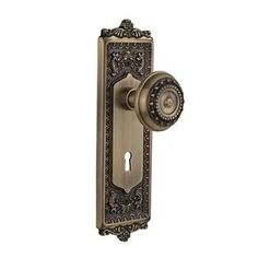 an antique style door handle with a decorative design on the front and side panel, in bronze