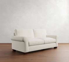 a white couch sitting on top of a wooden floor