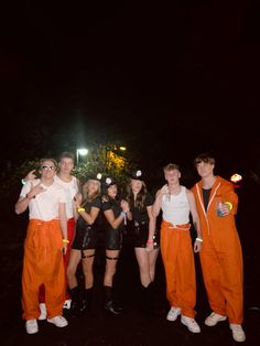 a group of young people standing next to each other in front of a street light