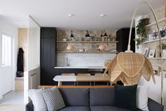 a living room filled with furniture next to a kitchen