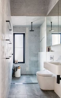 a bathroom with a white toilet sitting next to a bath tub and sink in it