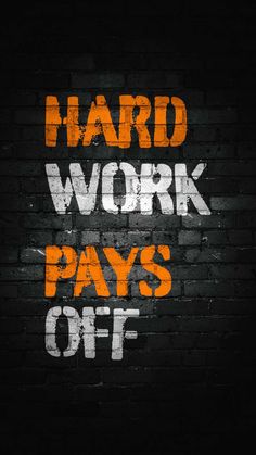 a brick wall with the words hard work pays off painted in white and orange on it