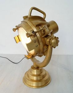 an antique brass desk lamp on a white table