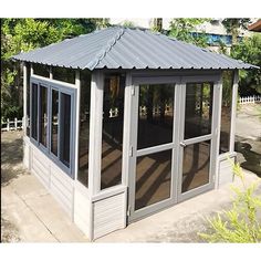 a gazebo sitting on top of a sidewalk next to trees