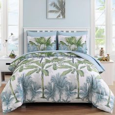 a bed with blue and green palm trees on it