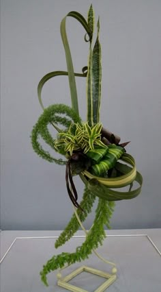 an arrangement of plants is displayed on a stand