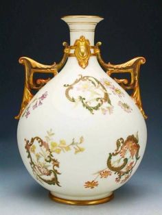 a white vase with gold decoration on it