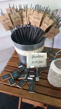 a table topped with lots of black and white tags next to a bucket filled with matches