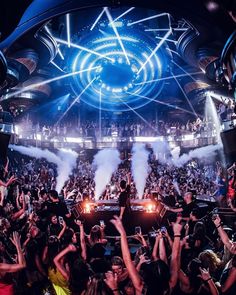 a crowd of people at a concert with their hands in the air