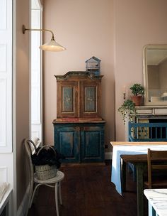 a blue cabinet sitting in the corner of a room next to a table and chair