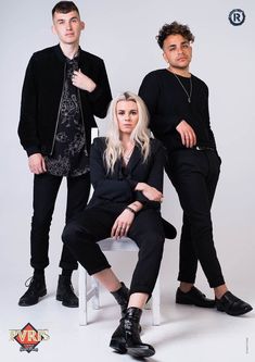 two men and a woman are posing for a photo in front of a white background