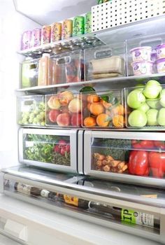 an open refrigerator filled with lots of fresh fruit and veggies in plastic containers