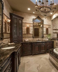 a luxurious bathroom with chandelier and marble counter tops