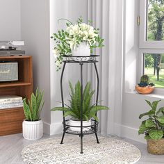 a potted plant sits on top of a metal stand in front of a window