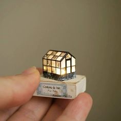 a miniature house is lit up on top of a piece of paper