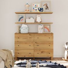 a child's bedroom with wooden furniture and pictures on the shelves above it, along with toys