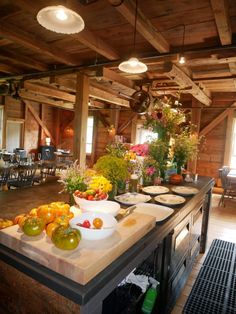 a kitchen with lots of fruits and vegetables on the counter top next to an island