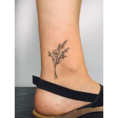 a small flower tattoo on the ankle