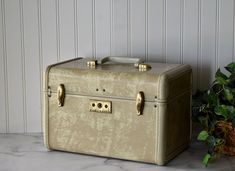 A classic vintage Samsonite Streamlite train case with a marbled beige exterior. It still has the original mirror, which is in good condition except for some scratches. The interior is also in good condition, but there are a few small spots and tears, and it's missing a fastener on the left side.  There are also some marks and scuffs on the exterior, including a tiny pink spot, possibly nail polish, on the lid (see photos).  No key or tray.   Approximate dimensions are 13"W x 9.25"H (with handle folded down) x 8.5"D.  Please be sure to review all measurements to ensure your understanding of the item's size. Also please review all the listing photos carefully before purchasing as they are a part of the description. The zoom feature may be used to examine details. Feel free to message me wit Train Case, Makeup Case, Vintage Beauty, Travel Case, Classic Vintage, Over The Years, Vintage Items, Marble, Nail Polish