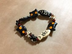 a bracelet with black cats and orange eyes