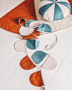 two decorative pillows with an umbrella on them sitting on the floor next to each other