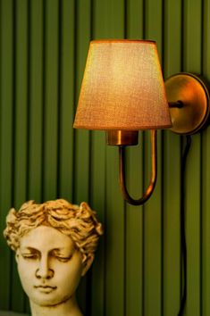 a lamp that is on the side of a wall next to a busturine