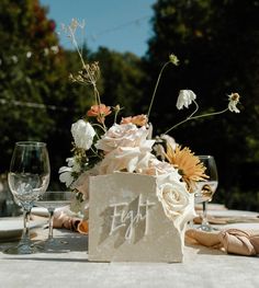 the table is set with flowers and wine glasses