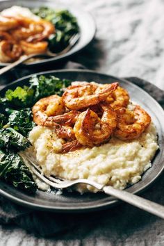 two plates with mashed potatoes and shrimp on them next to spinach, broccoli