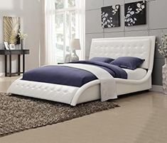 a white bed sitting in a bedroom next to a rug on top of a wooden floor