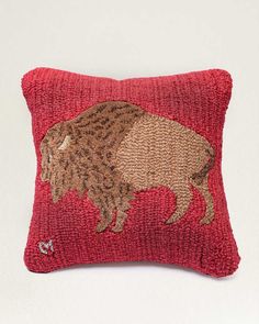 a red pillow with an embroidered bison on it