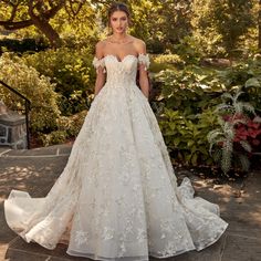 a woman in a wedding dress standing outside