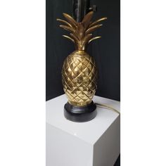 a gold pineapple lamp sitting on top of a white table